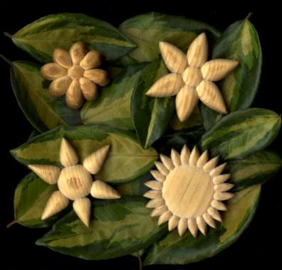 four wooden flowers carved from pallets